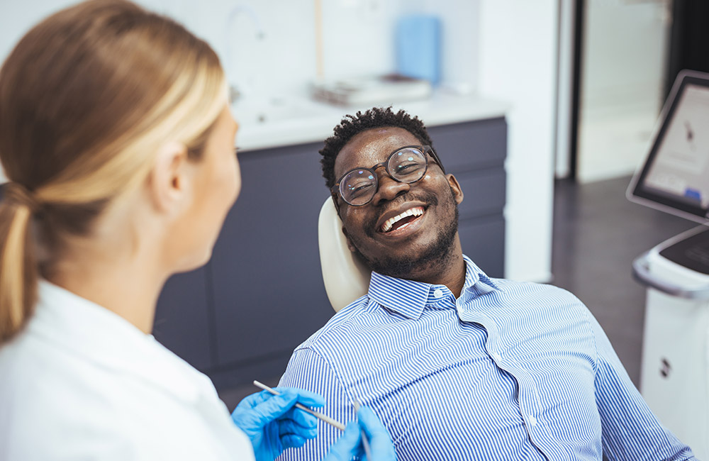 smiling patient after a full arch dental implant procedure