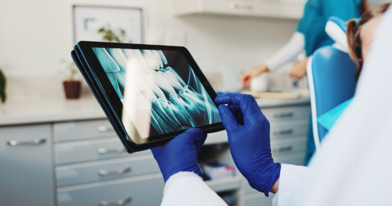 Medical, hands and dentist with xray on tablet screen for help, surgery information or diagnosis. Tech, oral surgeon and person in practice for dental implant, oral scan and tooth alignment procedure