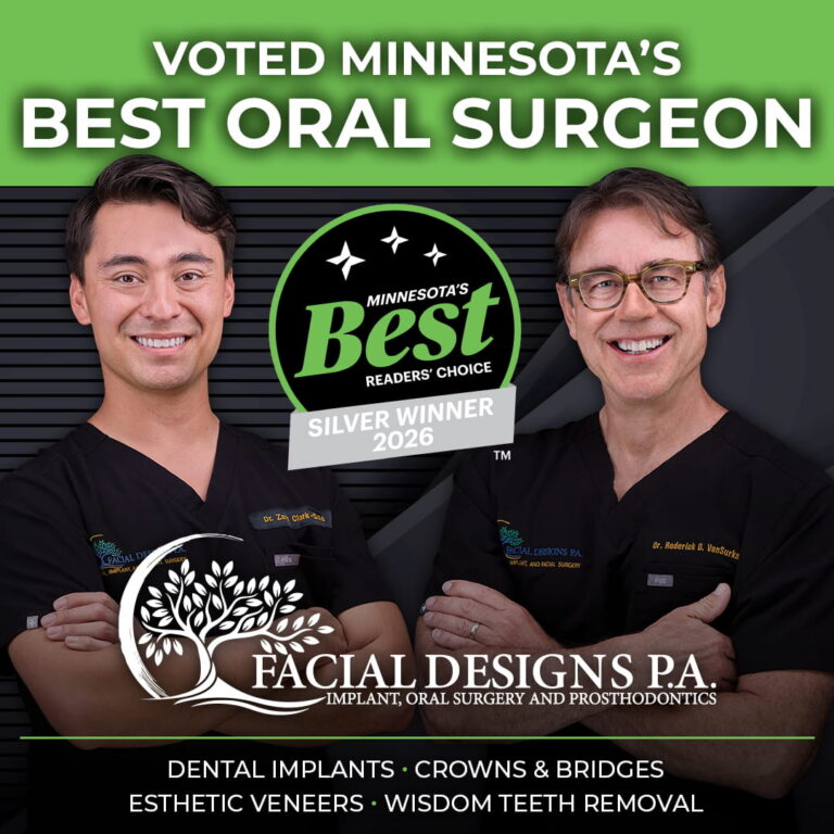 Dr. Clark-Gold (left) and Dr. VanSurksum (right) wearing black medical uniforms stand side by side against a dark blue background with diagonal lines. Both are smiling with arms crossed. Their scrubs display embroidered names and the “Facial Designs P.A.” logo. Above them is a stylized tree‑and‑crescent‑moon logo with the text “Facial Designs P.A. Implant, Oral Surgery and Prosthodontics.