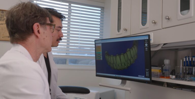 dr van and dr clark gold looking at a full arch rendering