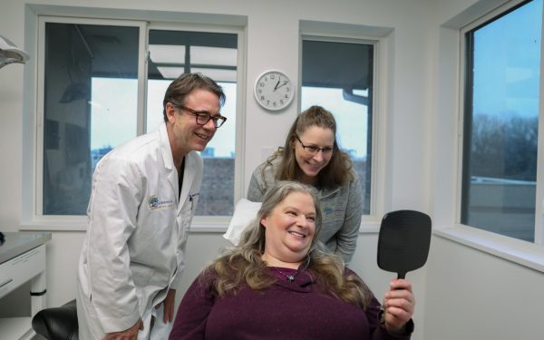 Dr. VanSurksum with a happy patient after a full arch dental implant procedure