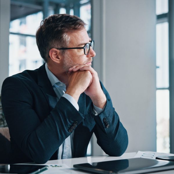 Business, thinking and man in office, solution and decision for career growth, doubt and problem solving. Person, employee and consultant in workplace, laptop and planning with choice and options