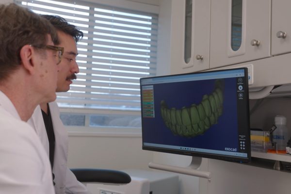 dr van and dr clark gold looking at a full arch rendering