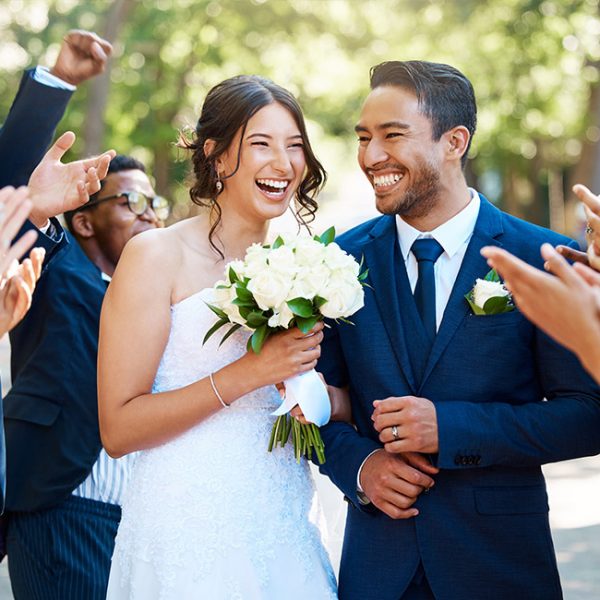 hot of bride and groom walking down aisle after wedding ceremony while friends and family celebrate